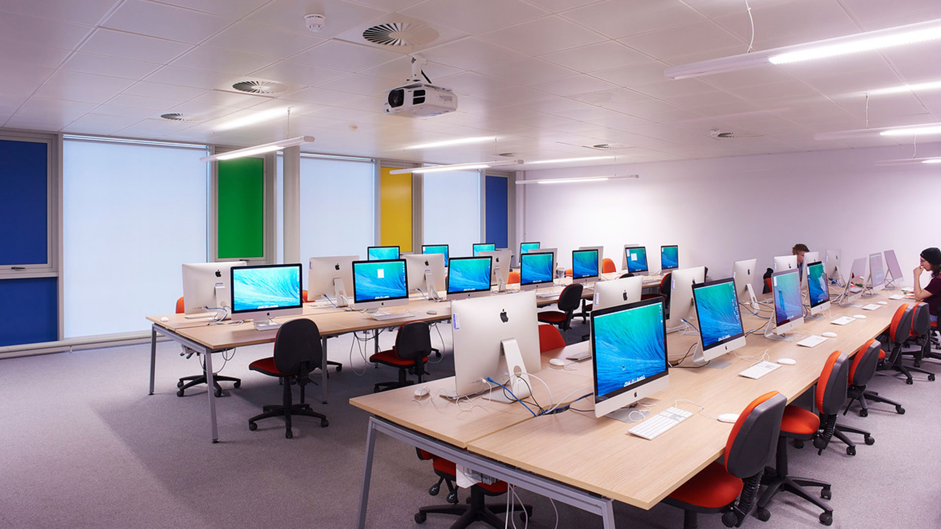 Creative Edge computer suite. There are two rows of desks all fitted with Macbook desktops