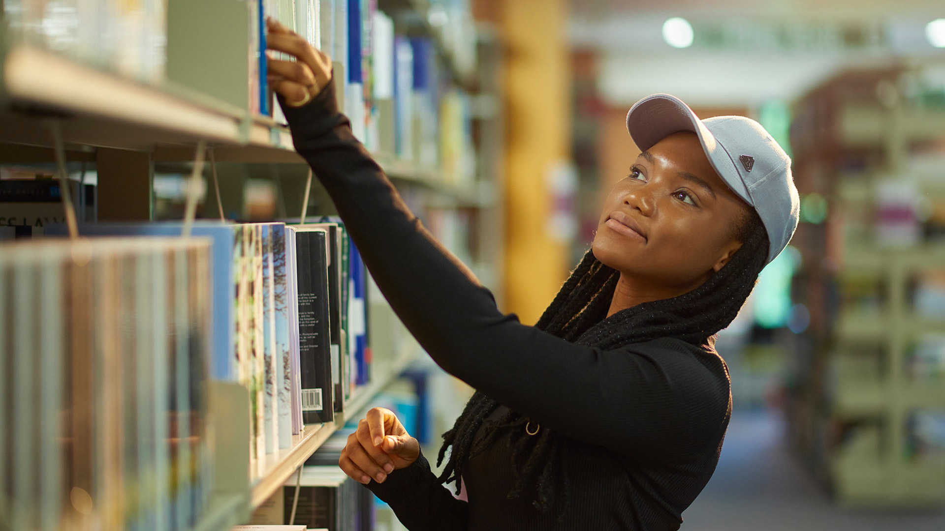 A student selecting a book in the library