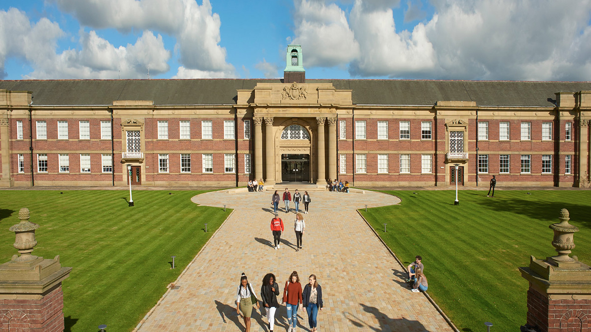 An aerial image of the Main Building entrance with students walking along the main walkway