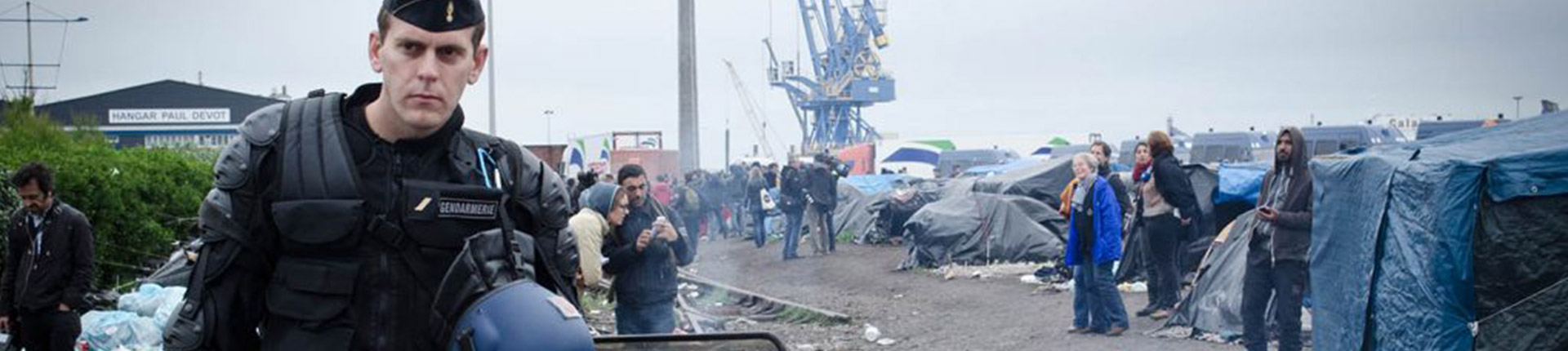 Riot police and protesters at a refugee camp