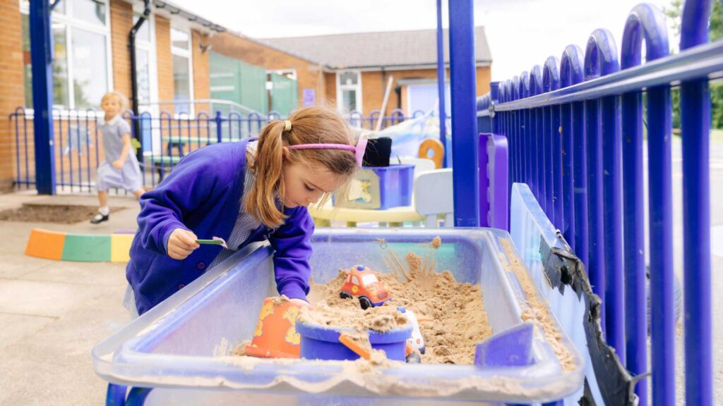 Early Years Education. School pupil playing in sandpit