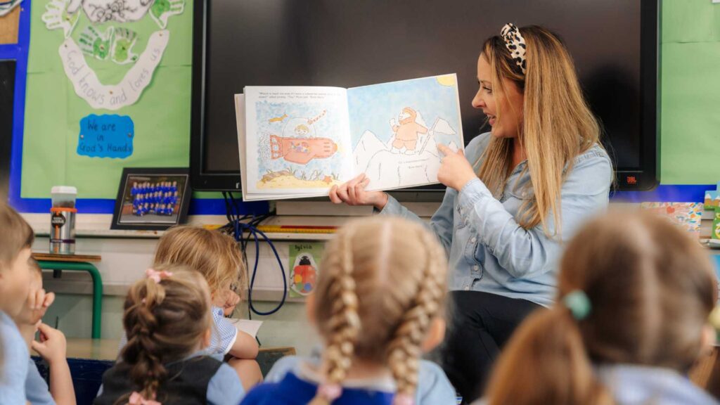 Early Years Leadership. Teaching reading a book to young school children