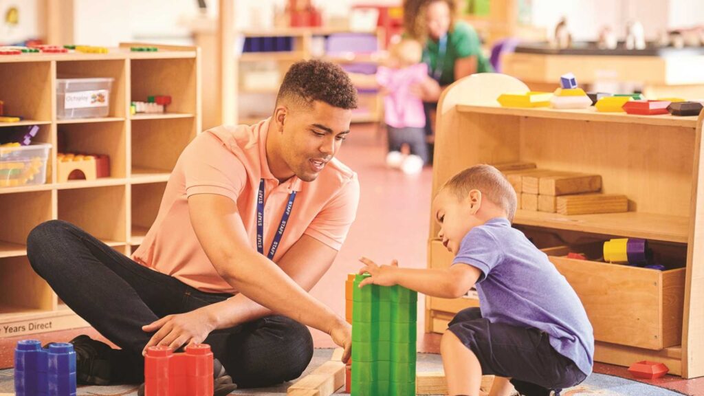 teacher and young child in an early years setting playing with blocks