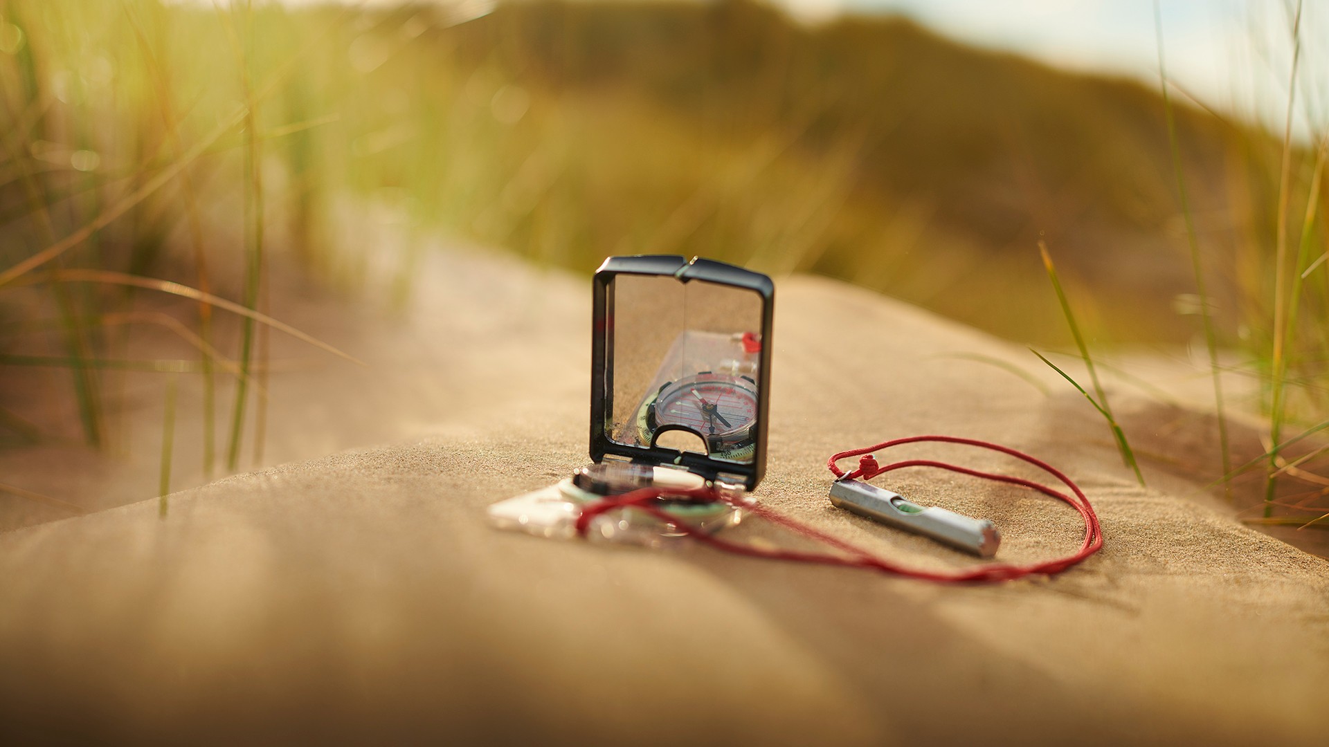 Close-up of a compass on a sand dune.