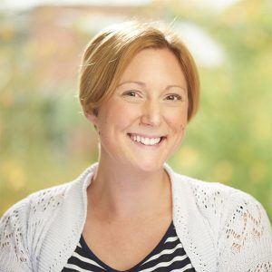 Dr Linda Kaye, smiling in front of a green background