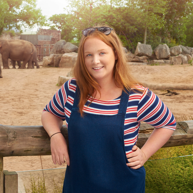 Meg Hughes stood in front of elephants.