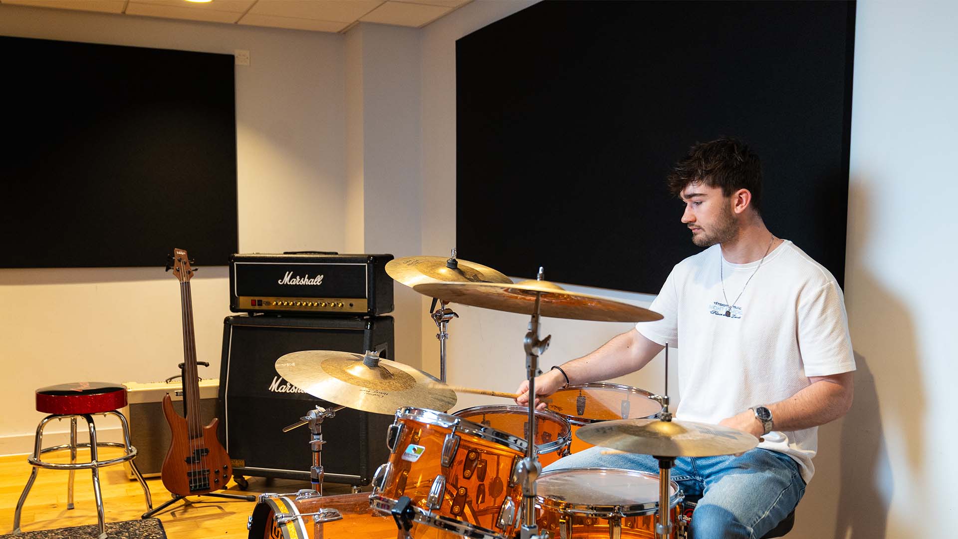 Music production student using a set of drums