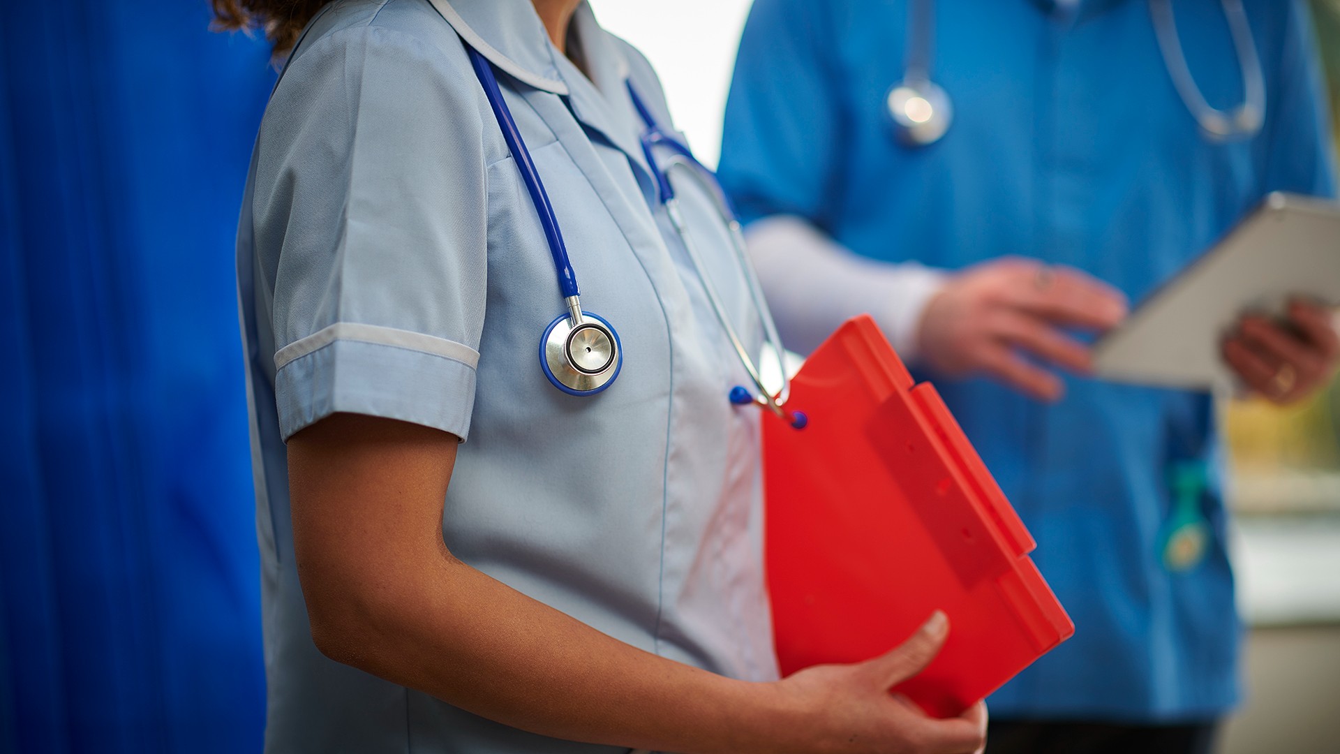 A shot of a student nurse carrying patient notes and a stethoscope