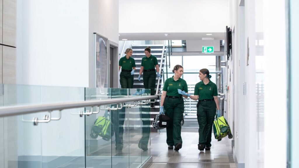Paramedics having a conversation whilst walking down a corridor.