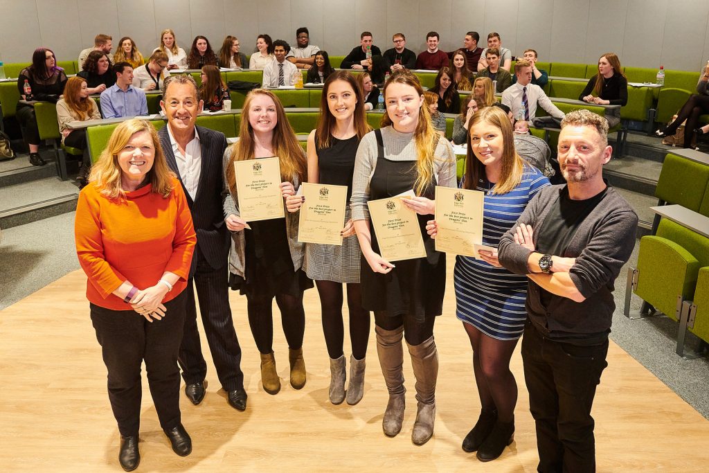 Students showing their certificates from participating in the Dragon's Den project. There are also some Psychology academics standing with them.