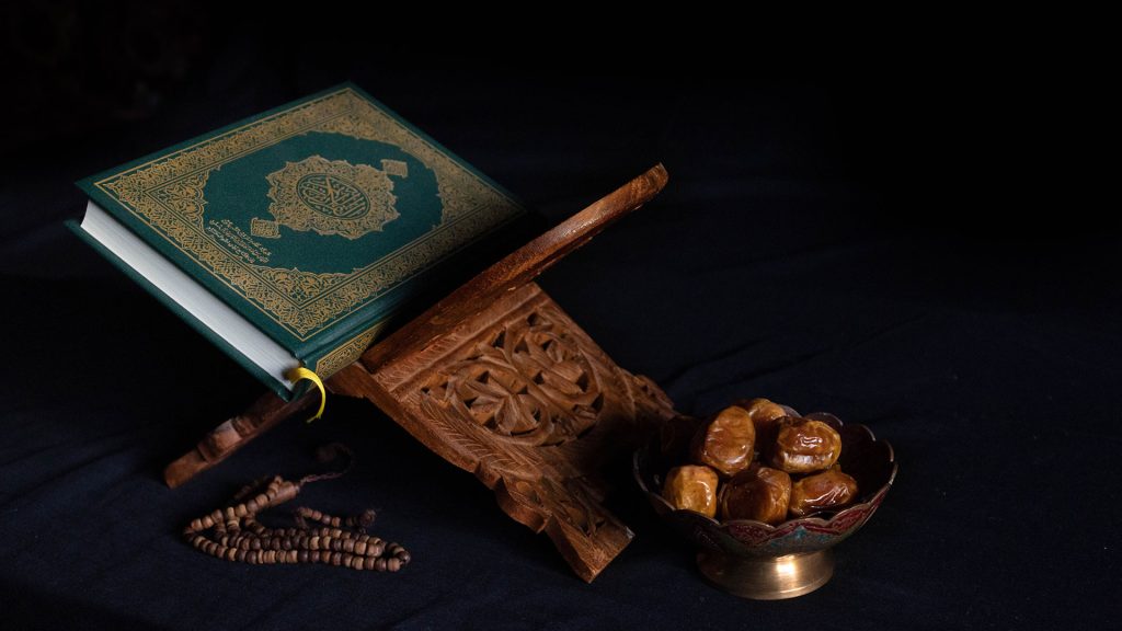 Quran The Holy Book and a Bowel of Dates, Dark Background