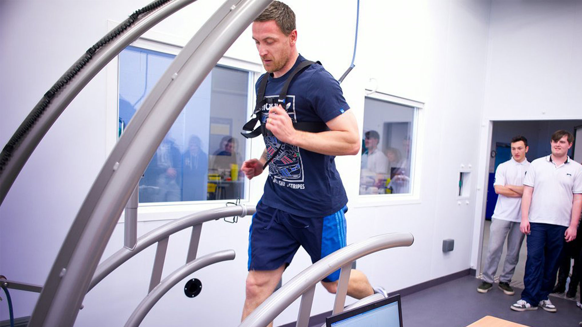 A man running on a treadmill attached to a heart monitor