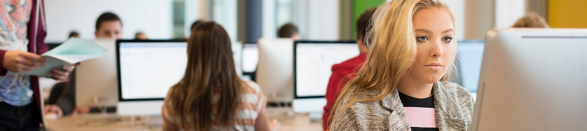 A student sat at a computer in a classroom