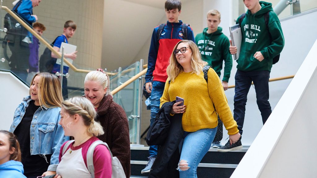 A group of students walking down the stairs in the Law and Psychology building