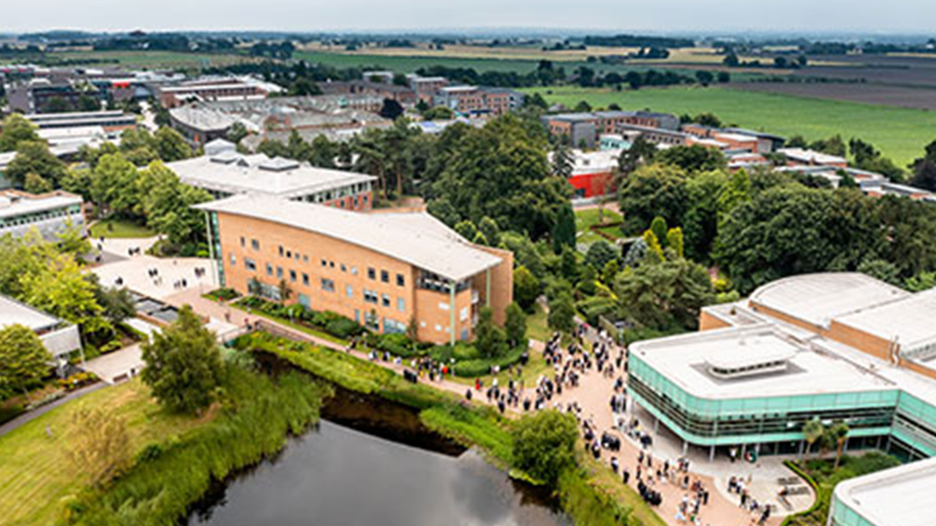A drone shot of the Faculty of Health and Clinical Skills building, with lots of people walking about on campus