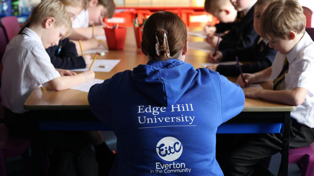 group of school children with student in tackling the blues hoodie