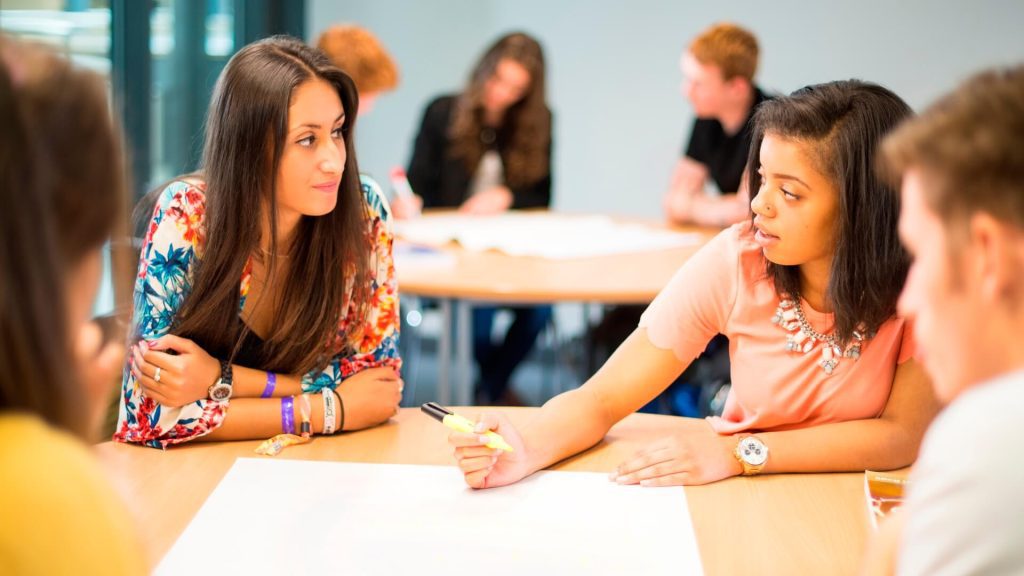 Four students brainstorm together during a seminar in the Business School.