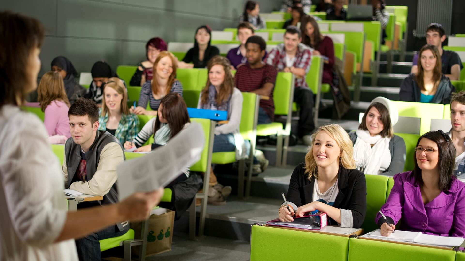 A lecturer addresses a busy lecture theatre of students in the Business School.