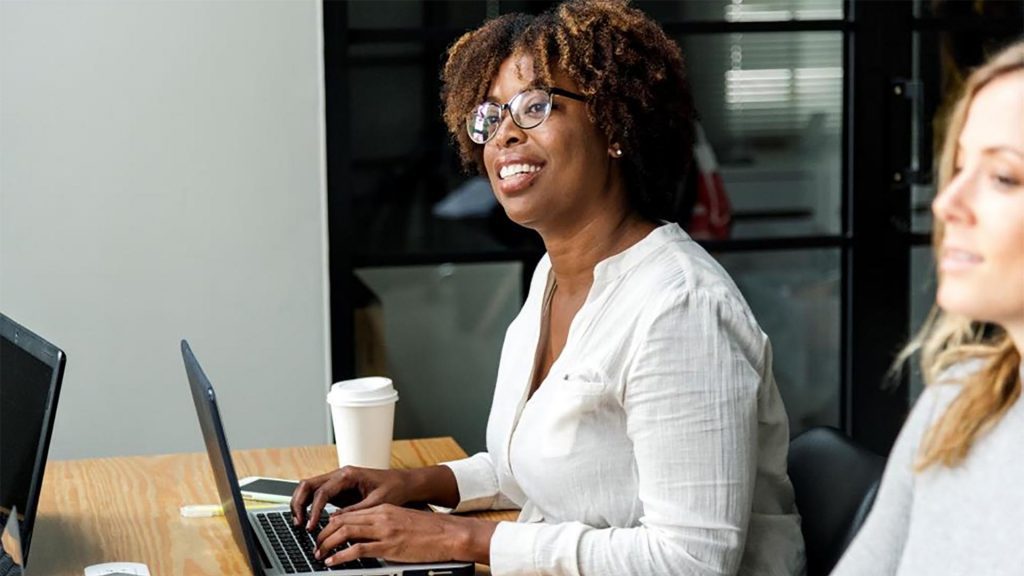 A woman in the Business School on her laptop in the leadership skills programme.