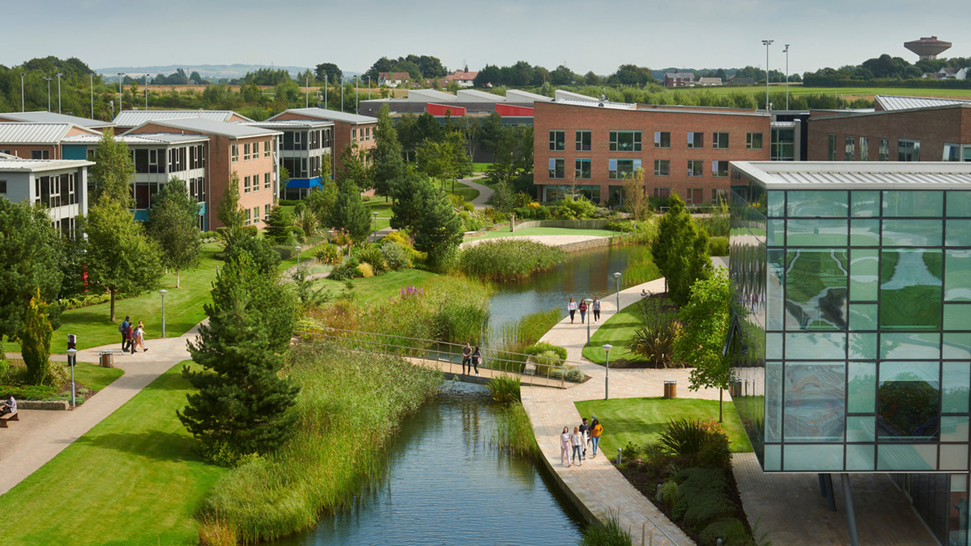 Shot of outside greenery and lake, surrounded by accommodation. Shot taken from the Catalyst rooftop