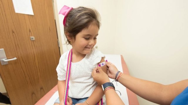 Young girl at the doctors getting a plaster put on her arm