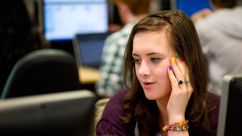A student sits in an IT suite during a seminar.