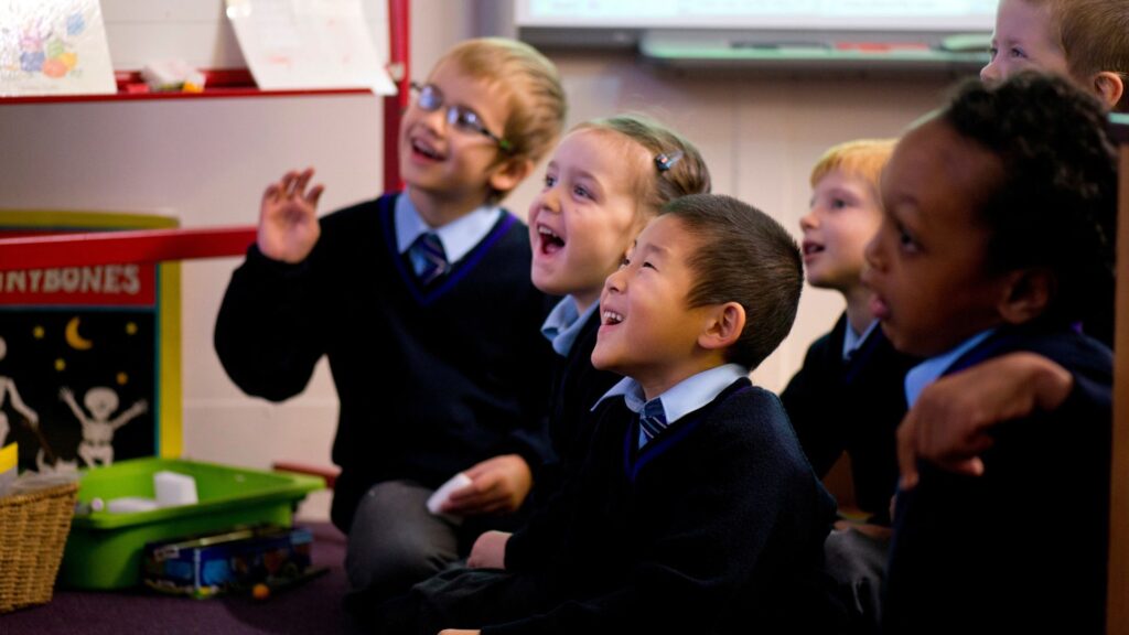 primary school children sat on carpet in classroom