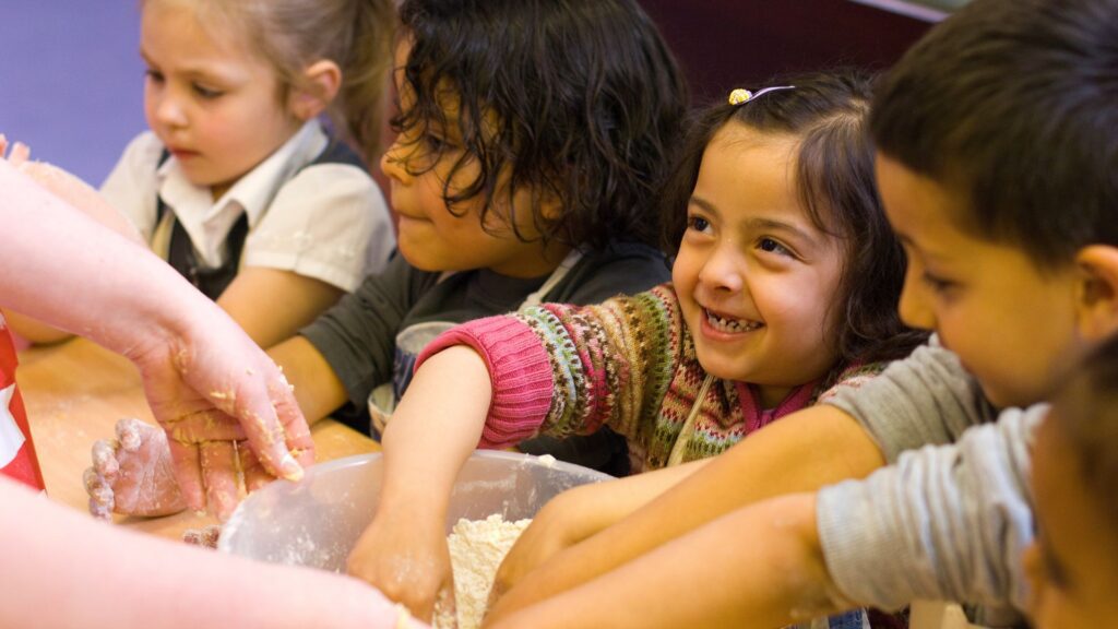 early years children baking around a table