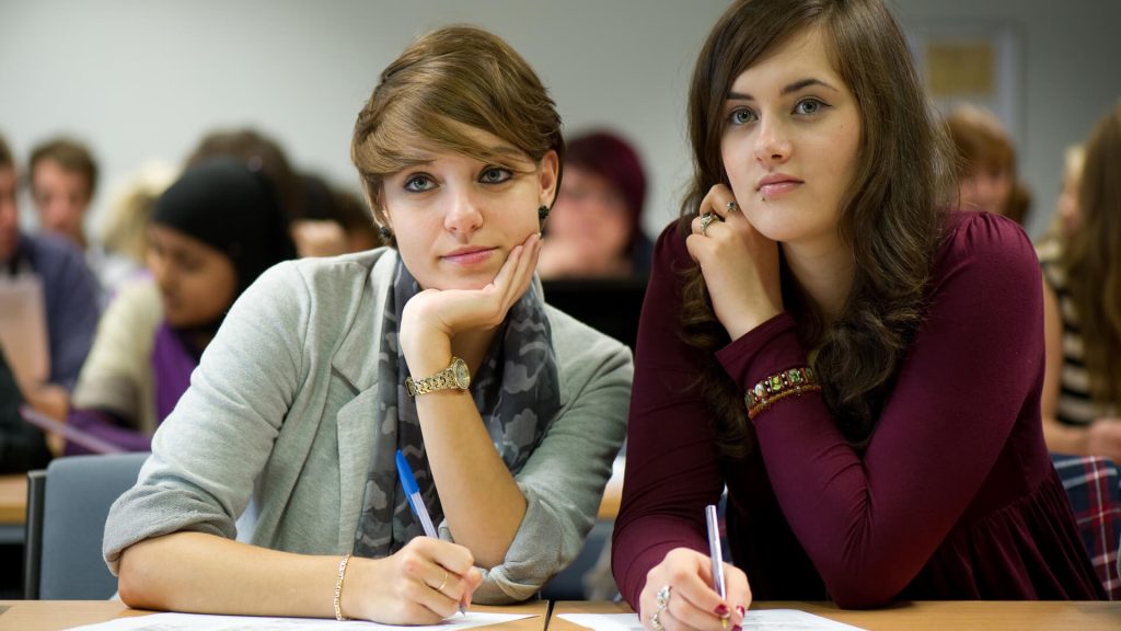 Two students listen to their lecturer during a seminar.