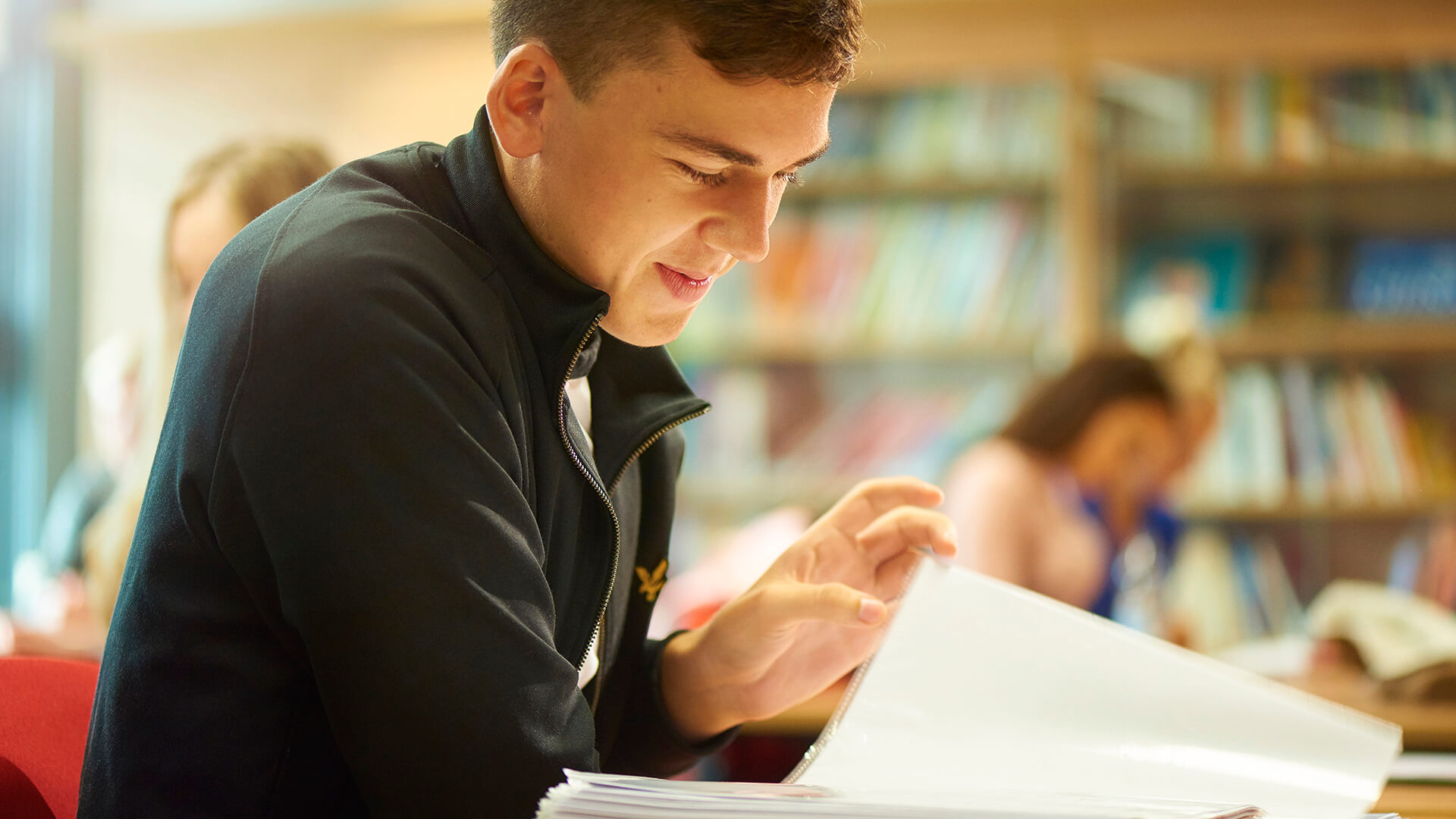 A student flicks through their notes during a seminar.