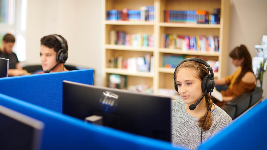 Students listen on headphones in a classroom in the Language Centre.