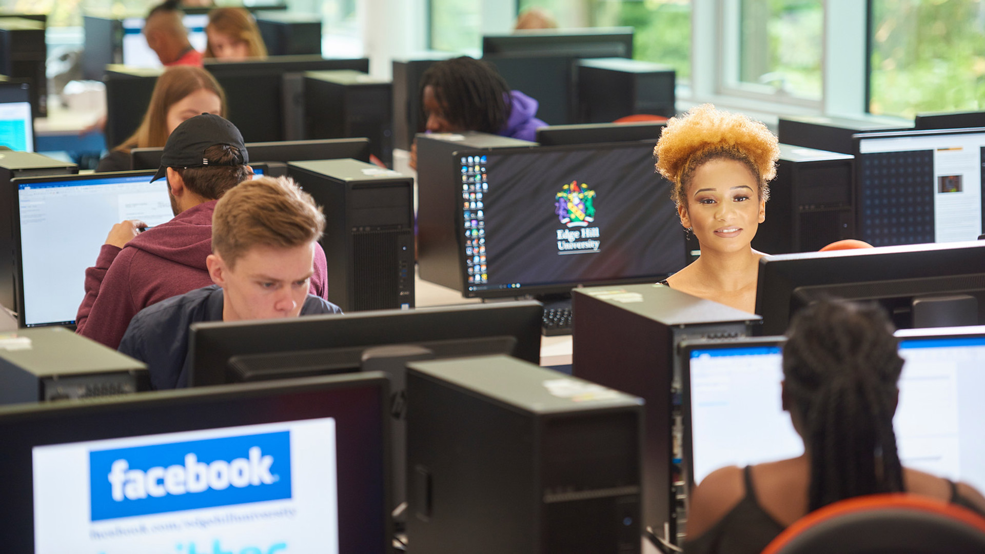 Group of students sat in front of computers studying