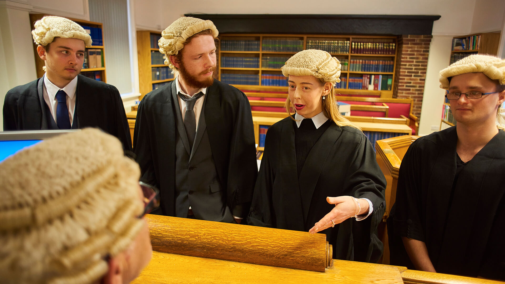 Students practice their mooting skills in a mock courtroom and consult with the judge.