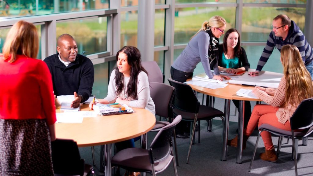 Students gathered round two tables during a Social Work seminar.