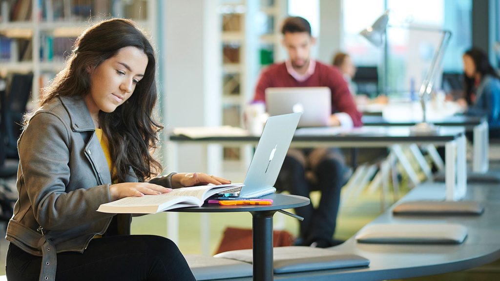 Student studying with book and laptop