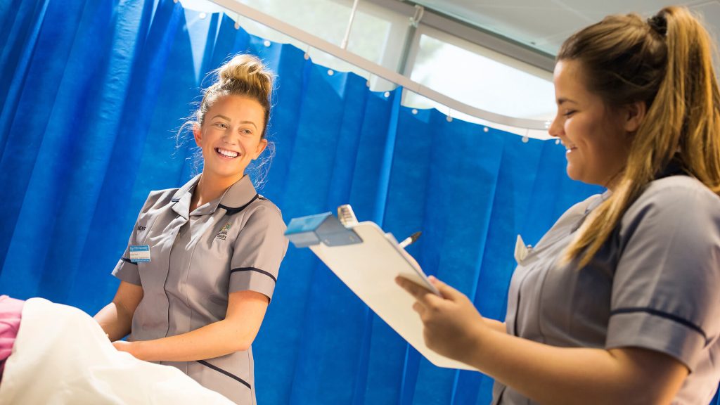 Student nurses practice recording patient information in the clinical skills suite.