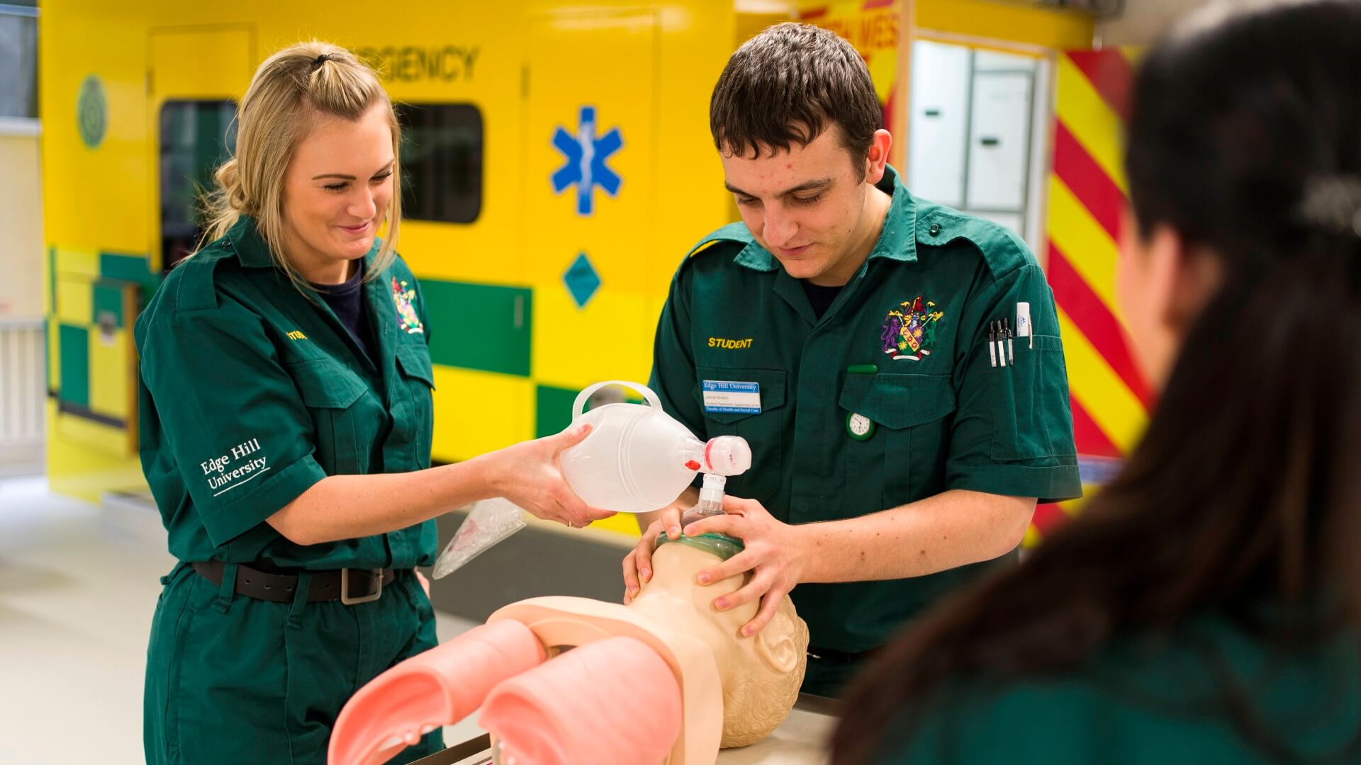 Three students hone their skills on a mannequin in a clinical skills simulation suite.