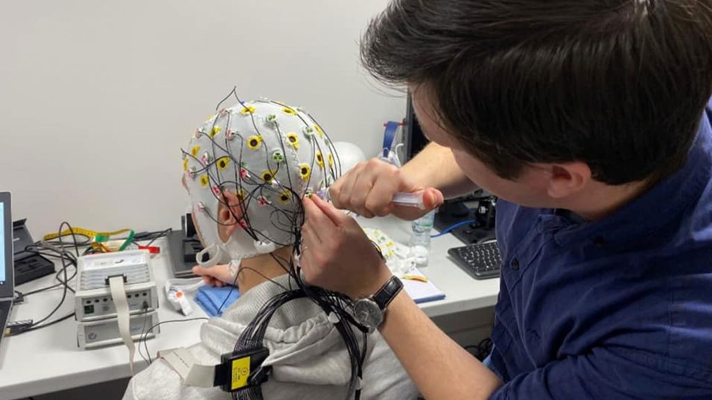 Psychology student doing ECG testing on another person