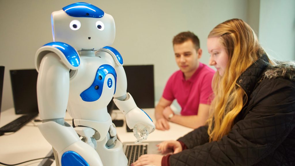 Students operate a robot in the Tech Hub.