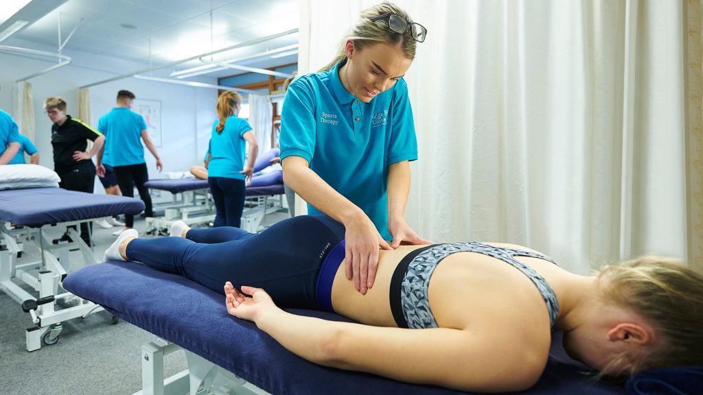 A student is massaged by one of their peers to hone skills in sports therapy.