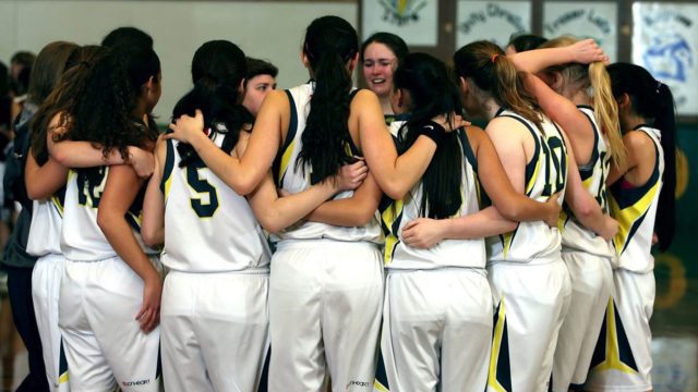 A team of girls huddled at a time out