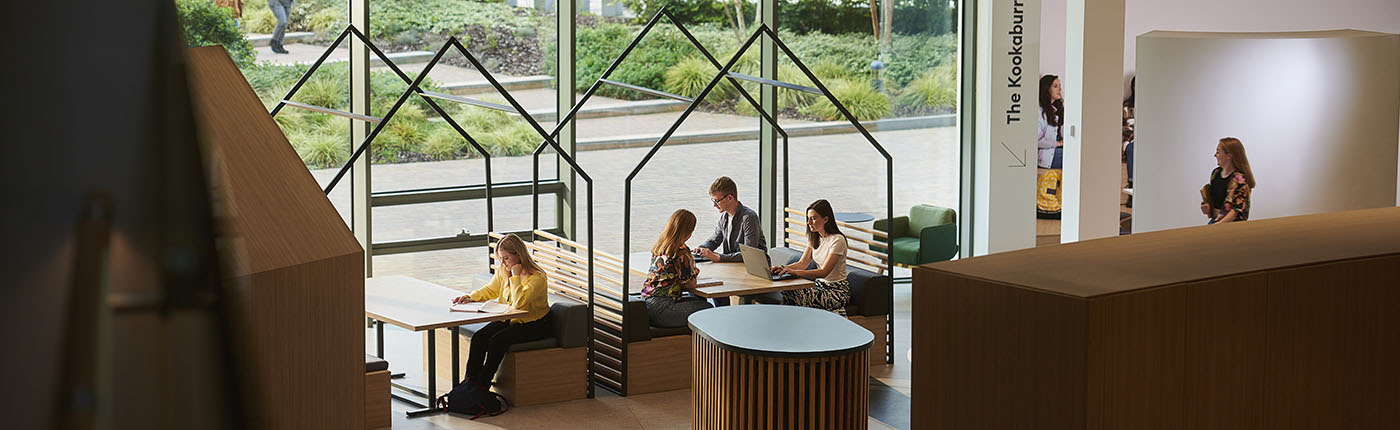 Several students at different desks and stations in the Catalyst building.