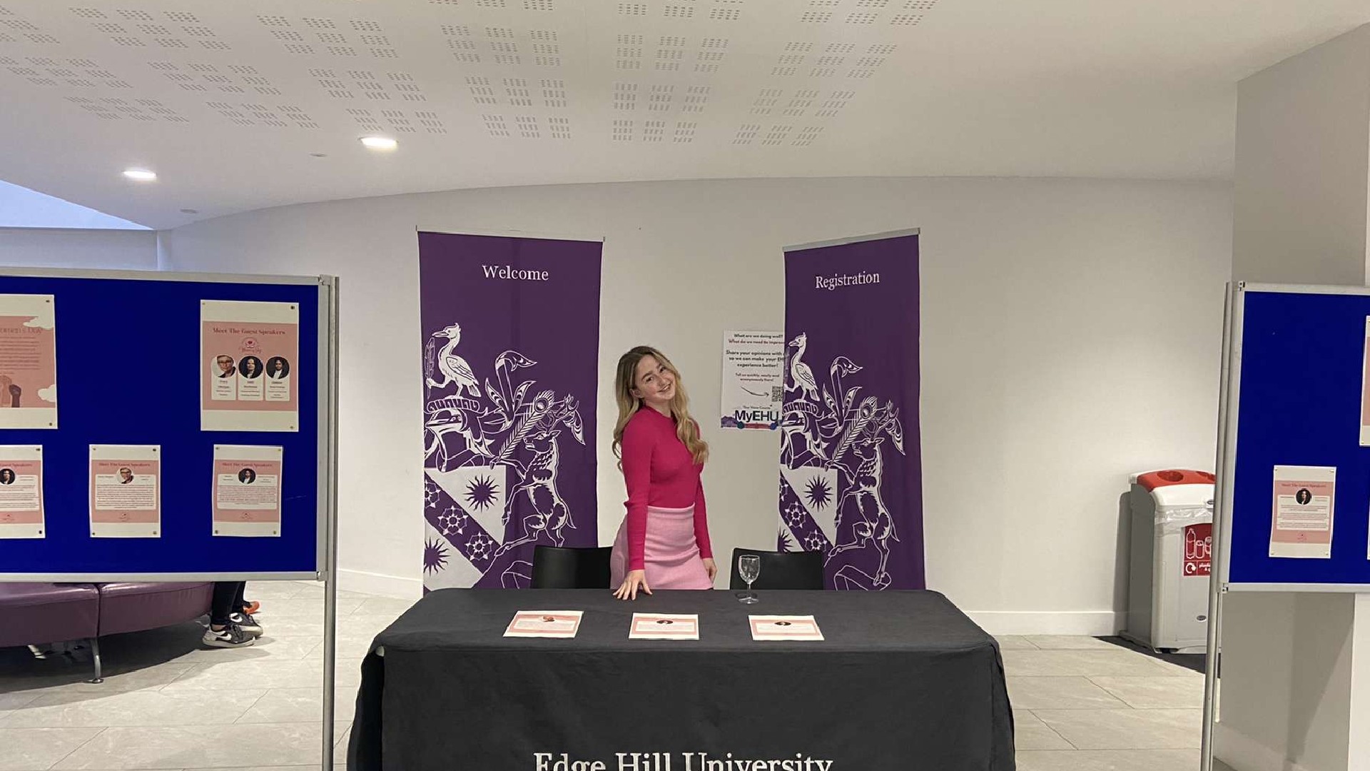 An image of Megan Gough stood behind a table that says "Edge Hill University"