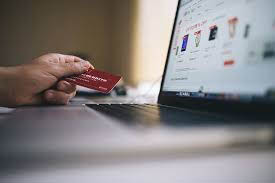 Someone holding a credit card in front of an online payment screen