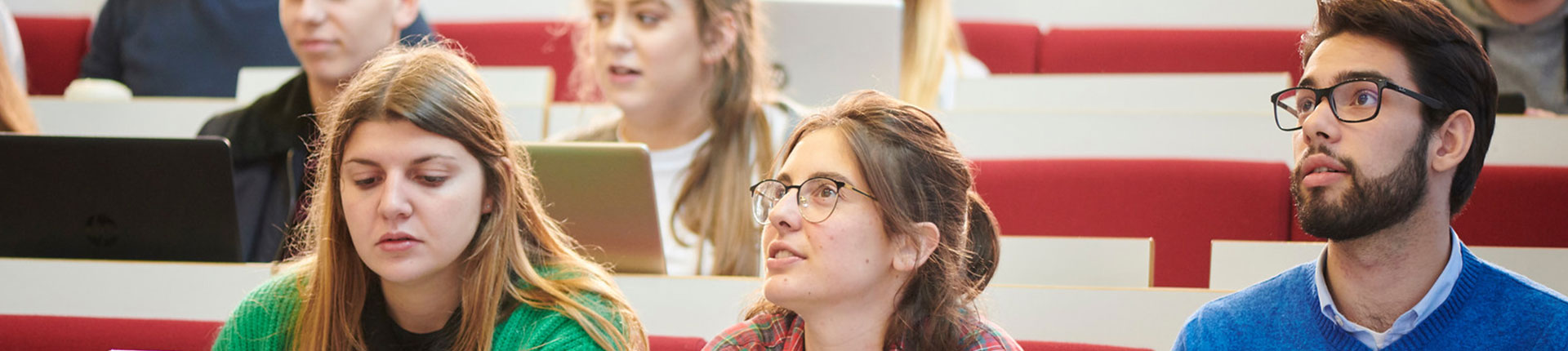 Three students attending a lecture in the Business School