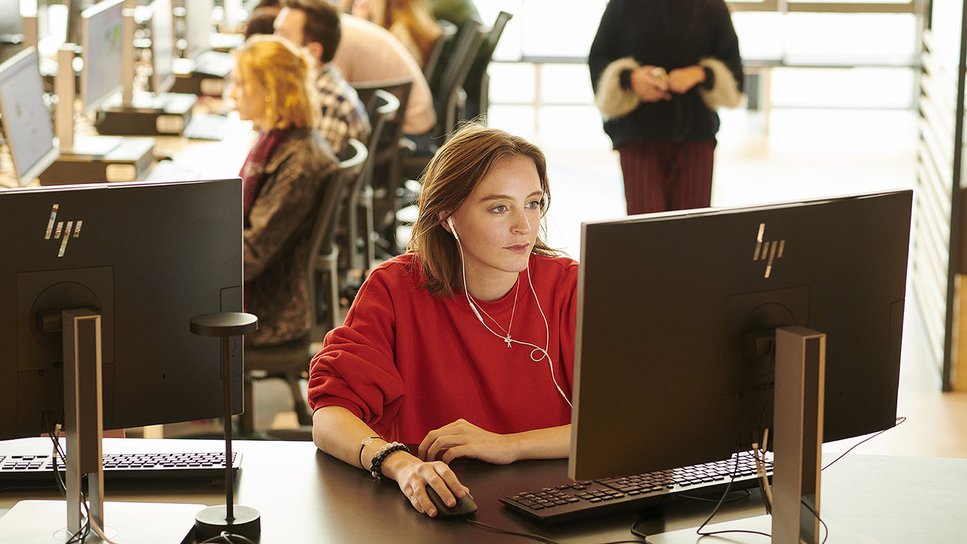 A student works at a computer in the Catalyst building.