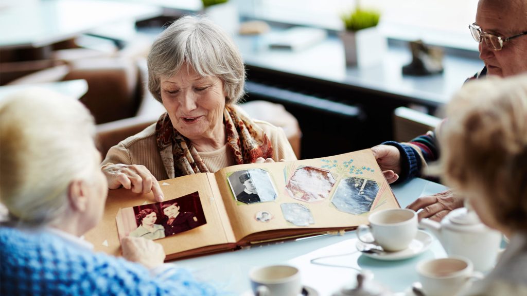 Elderly people looking at a photo album together