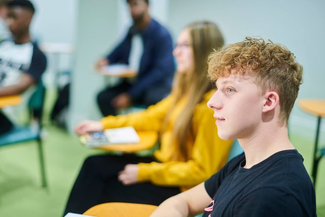 A student listens attentively during a lecture.