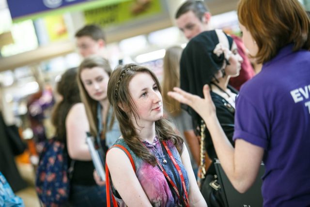 A prospective student receives advice from a member of Edge Hill staff during a UCAS exhibition.