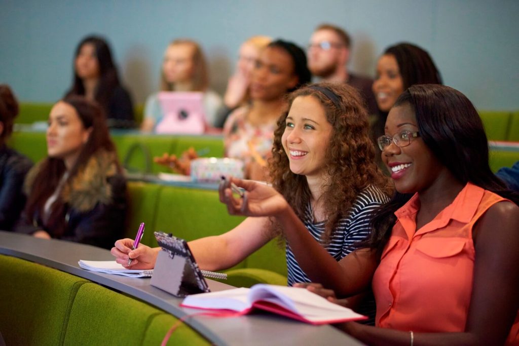 Two students attend a lecture in a Harvard-style theatre in the Tech Hub.